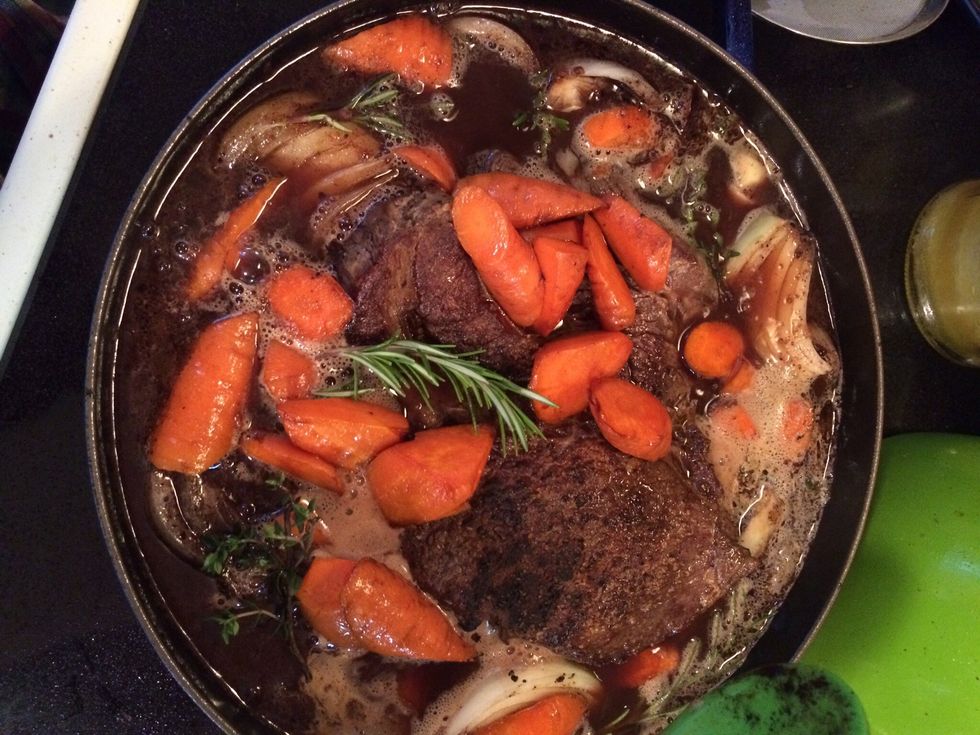 Add the onions, carrots, and herbs to the meat and stock. I also added 4 whole cloves of garlic even though the recipe didn't call for it. It just seemed so wrong not to have garlic along with it!