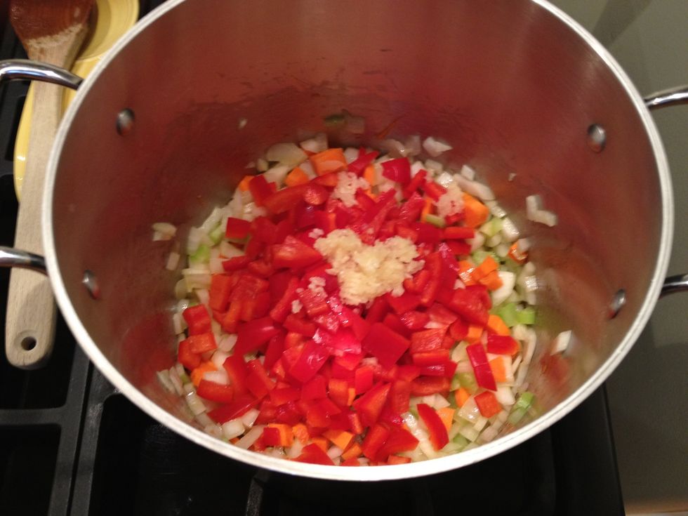 Add the red peppers and the garlic to the pot. Stir, and cook until the garlic is fragrant.