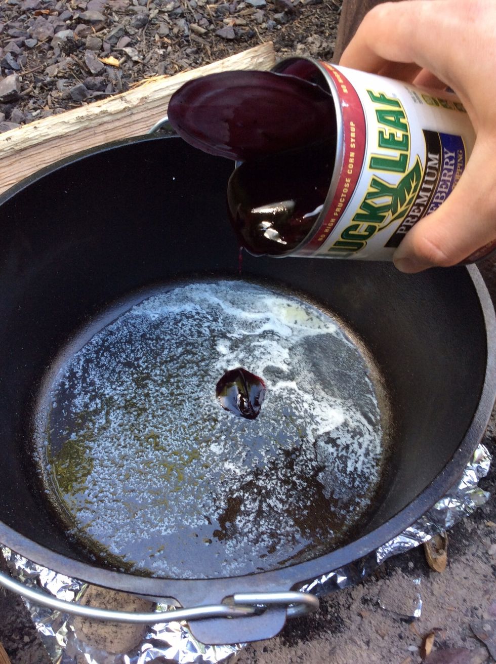 Add the remaining 1/4 stick of butter and melt it. Add in the can of blueberry filling to the Dutch oven.