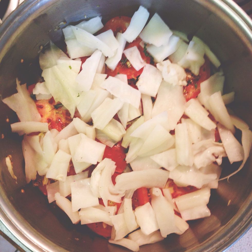 Add the remaining handful of dried mint over the sliced tomatoes. Then, add some of the chopped cabbage stems you put to the side, spreading them evenly over the tomatoes.