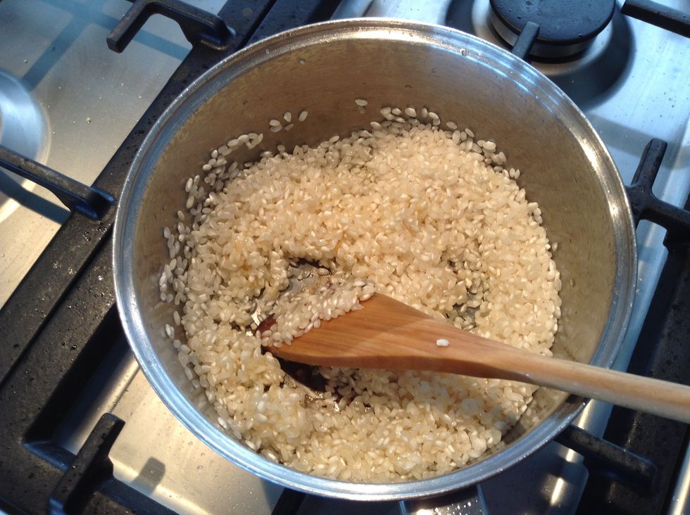 Add the rice and stir into the olive oil until the rice changes colour.