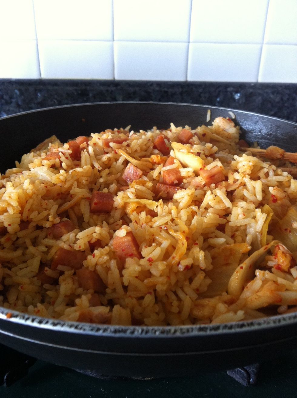 Add the rice, kimchi sauce, soya sauce and stir well until the rice changes colour.