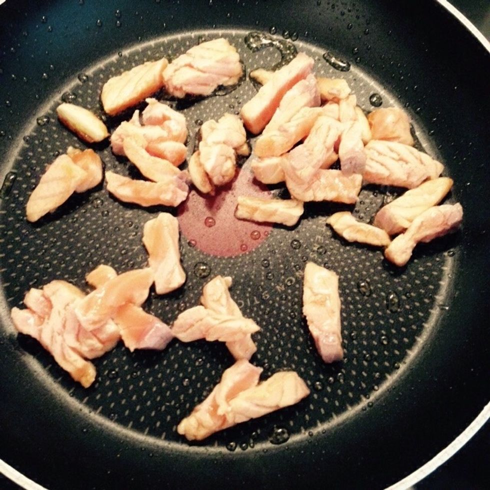Add the salmon pieces once the garlic is lightly roasted