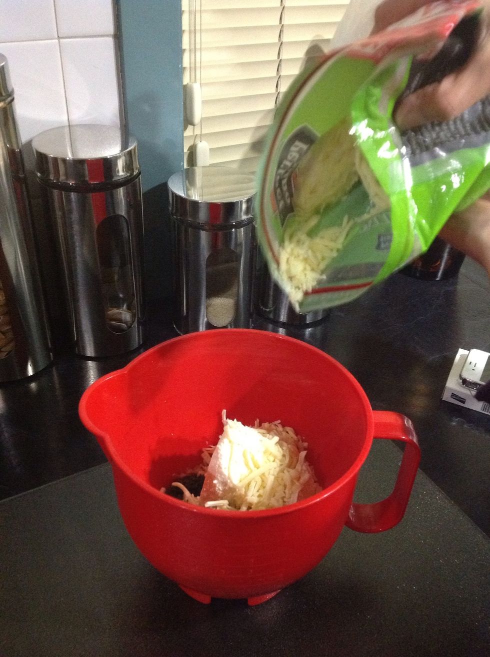 Add the shredded cheese  in the bowl with the spinach and the ricotta