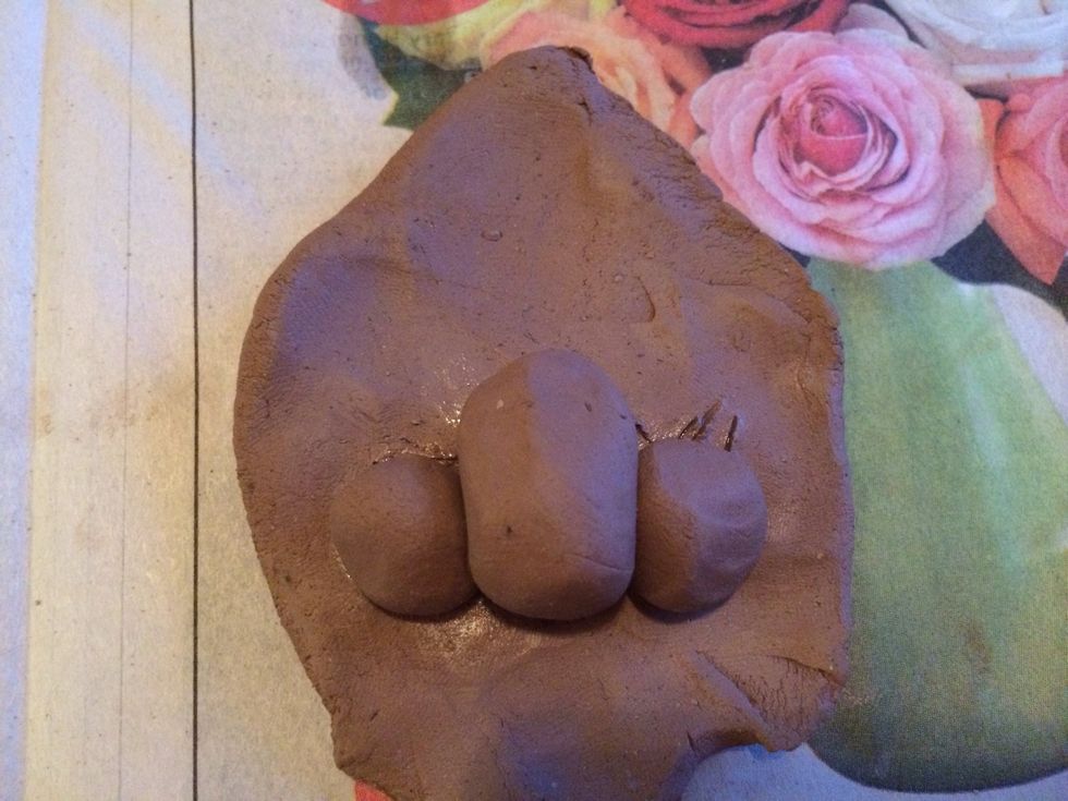 Add the spheres to your clay, small spheres on each side. These will be the nostrils and the tip of the nose.