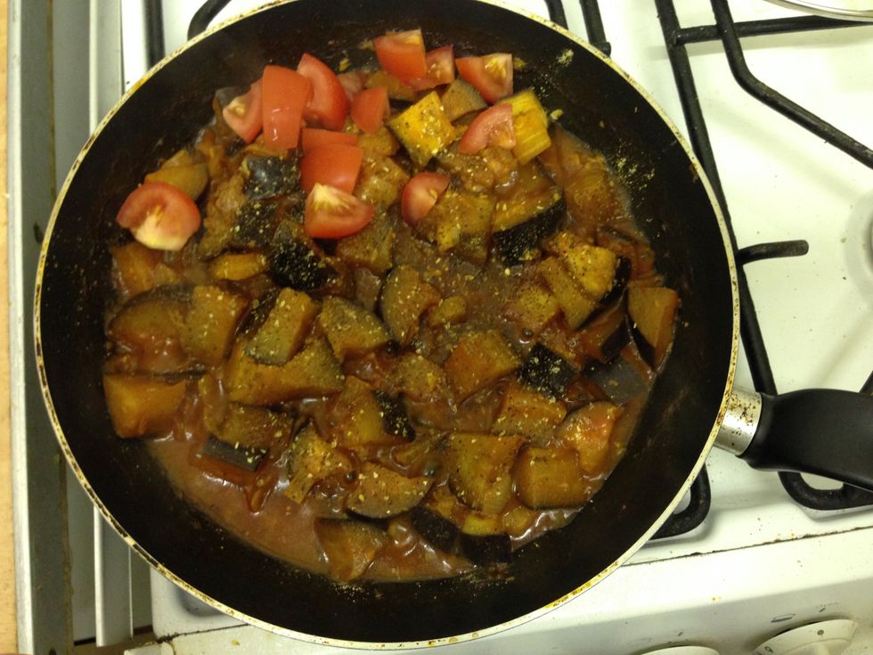 Add the spices to the aubergine and mix. Chop the tomato in there too. Leave to simmer for another 4 minutes until aubergine is soft