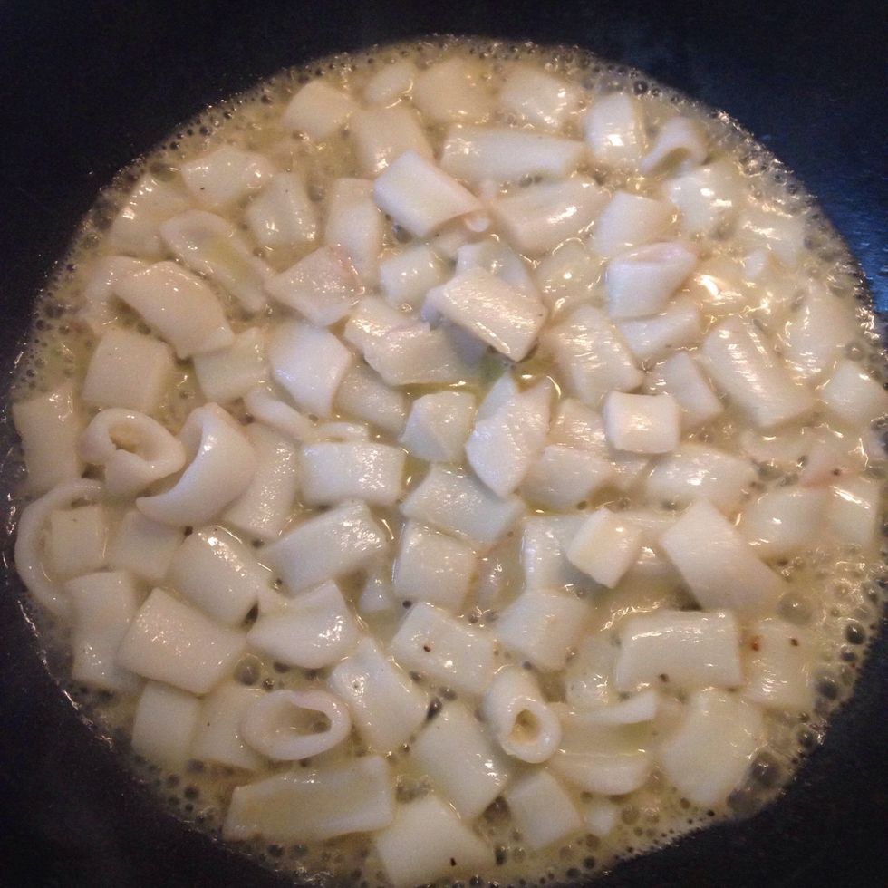 Add the squids, wet with the wine and soothe with a cup of bouillon after the wine dries. Let cook for 10 minutes