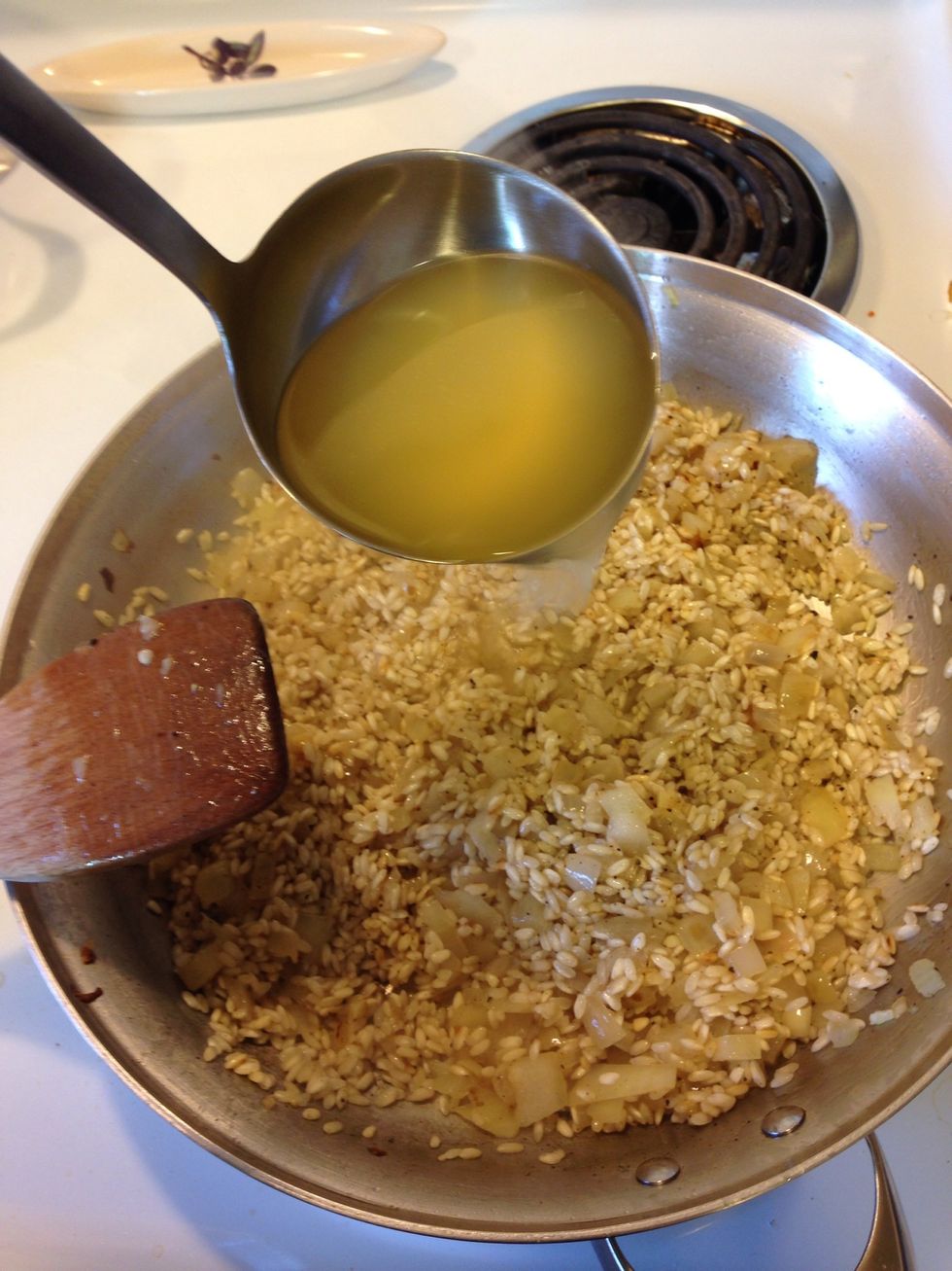 Add the stock, one ladle at a time and stir, and stir! Until the liquid absorbs then add another ladle full