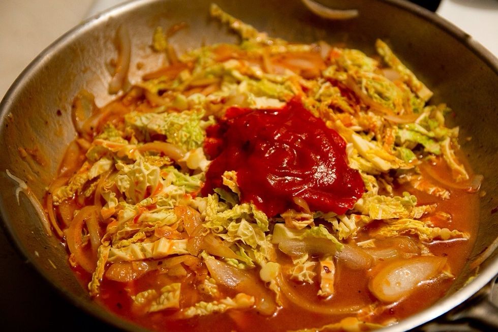 Add the stock, tomatoes, cabbage and tomato sauce and bring to boil.