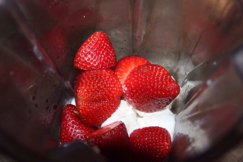 add the strawberries and some milk to the blender and mix everything together!