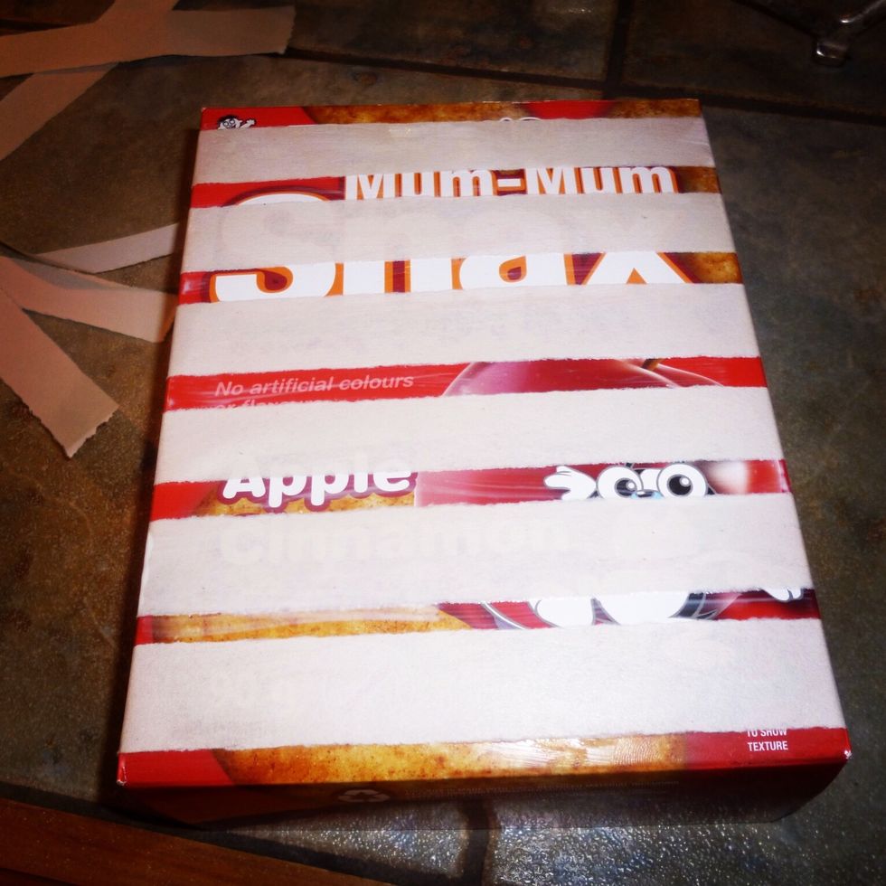 Add the strips of newsprint using Mod Podge or liquid white glue. Keep adding layers of newsprint until the entire outside of the box is covered. Once the box is covered then allow to dry.