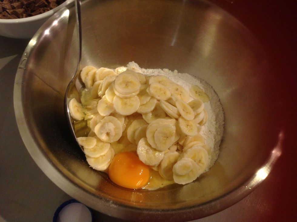 Add the thinly sliced bananas and egg into the mixing bowl with the raising flour.