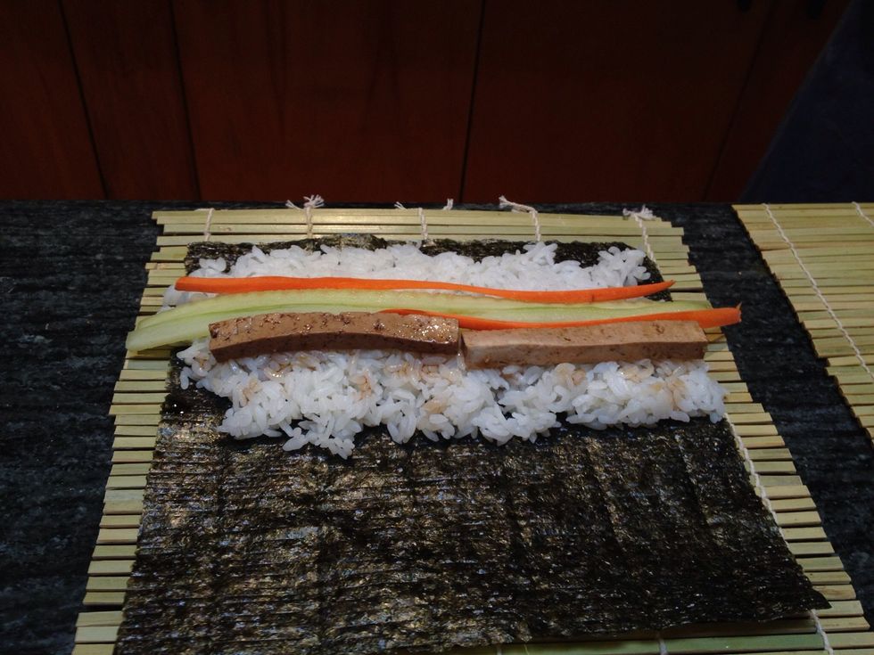 Add the tofu strips. Be careful not to add too much or it will be hard to roll. Also don't stack the ingredients or it won't look pretty. If everything is next to each other it rolls up looking nice.