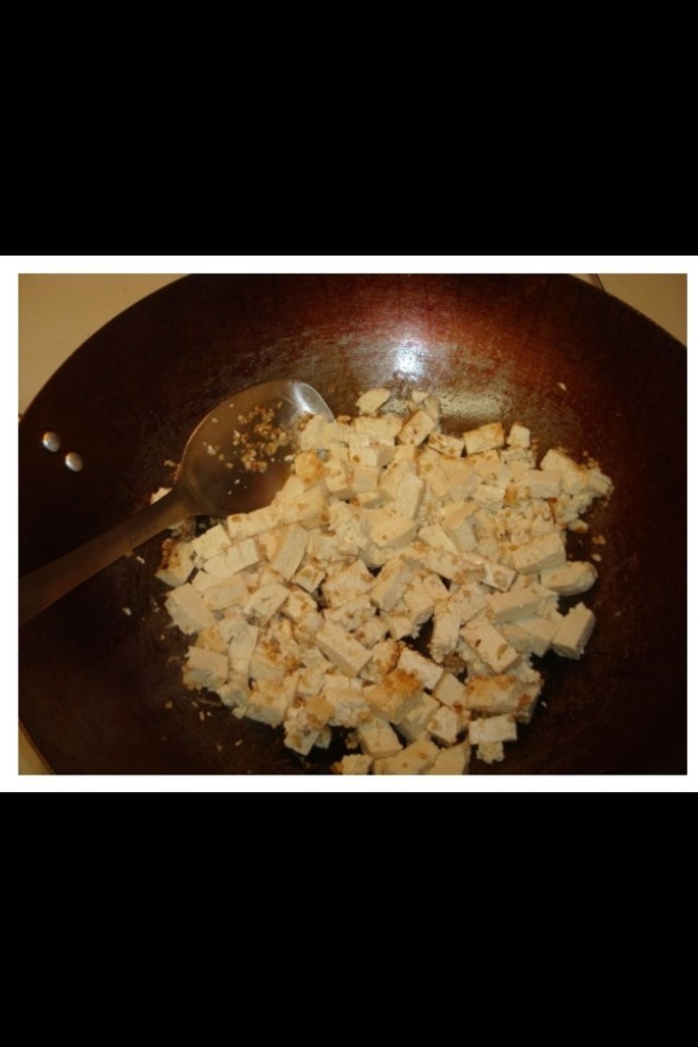 Add the tofu to the garlic and stir fry as it browns.