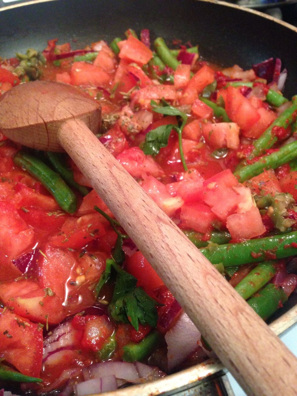 Add the tomato olives and spice blend - then 1/2 cup water