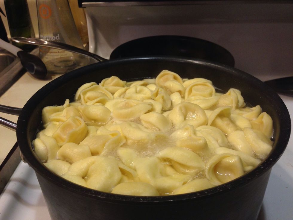 Add the tortellini to water and hole the water to just under a boil.  Do not let the water boil it will break apart the tortellini. Cook in till the pasta is al dente.