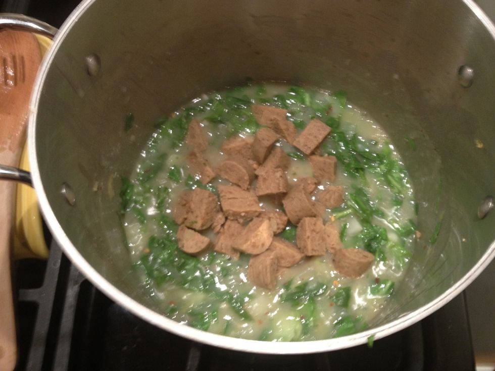 Add the vegan sausage and simmer for another couple of minutes. Depending on how tough your greens are, you may need to cook for a longer period of time. Adjust the salt and pepper to taste.