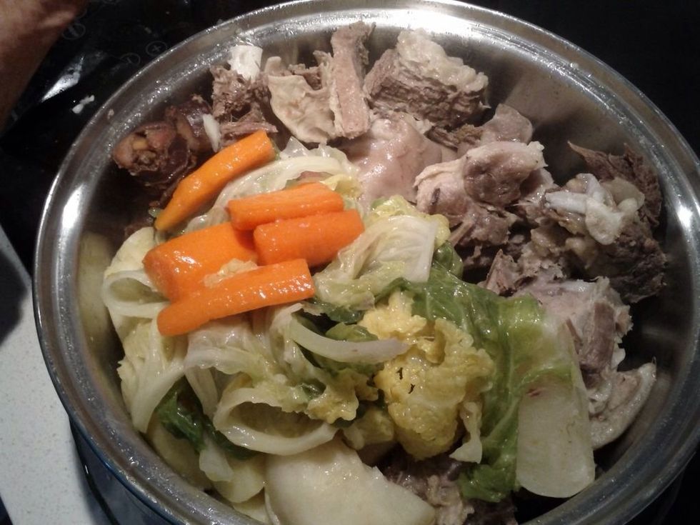 Add the vegetables to the beef, pork, sausages and potatoes.
