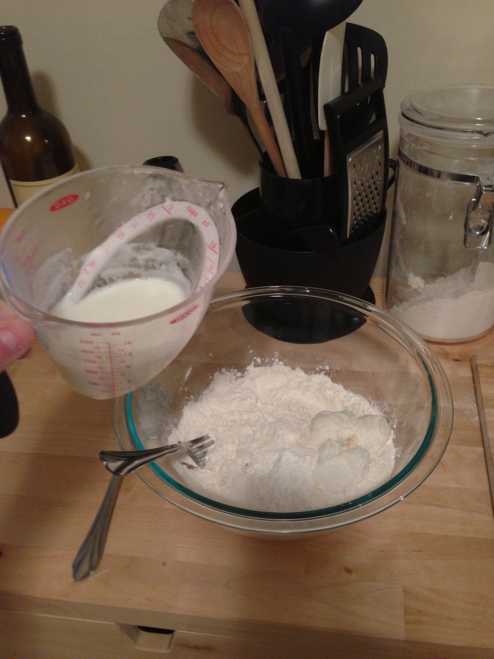 Add the warm milk to the flour mixture and mix. I used a whisk initially and moved to kneading when it became hard to whisk.