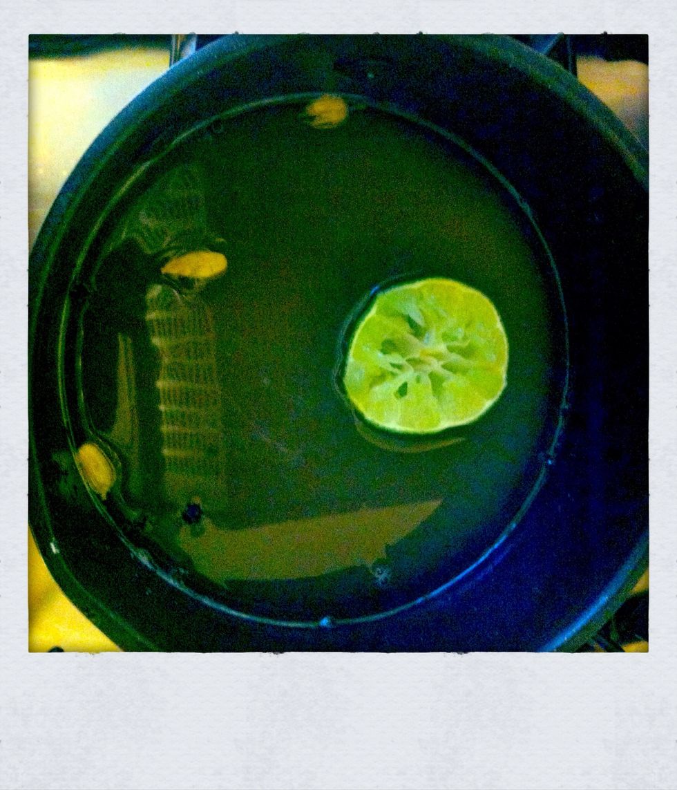 Add the water into a pan with the sugar, black pepper and the cracked cardamom and now squeeze in the juice of the whole lime but only add one half to the mix.