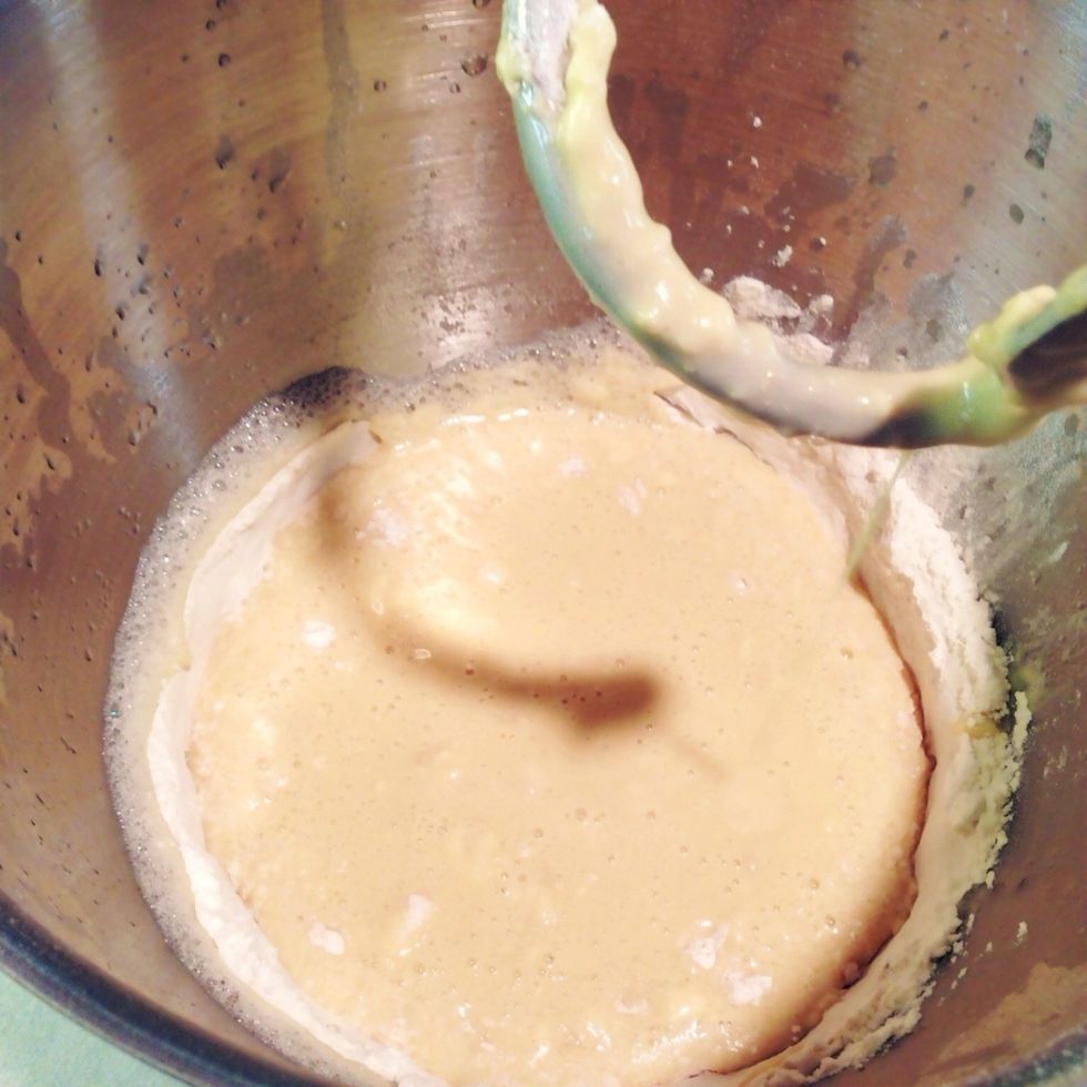 Add three cups of the flour to mixer. Also add two packets instant active dry yeast.