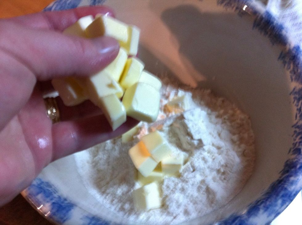 Add to flour. You could use 1/4 cup of any solid fat, like Crisco, lard, or coconut oil solid..but I like the butter.