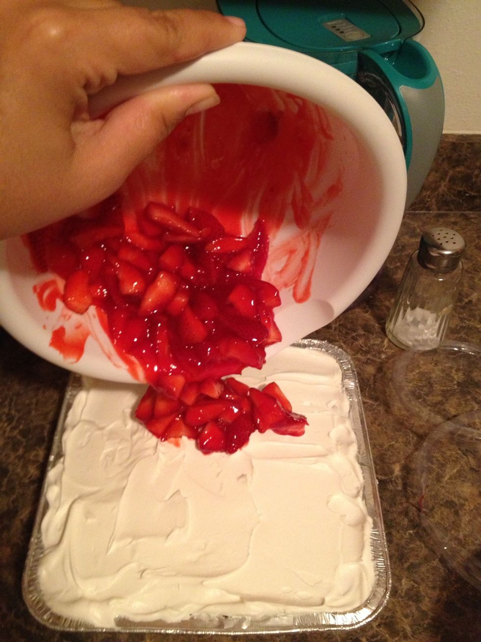 Add to the cake and spread it around evenly. Try not to get the whip cream too much as you're spread your strawberry mixture on top.