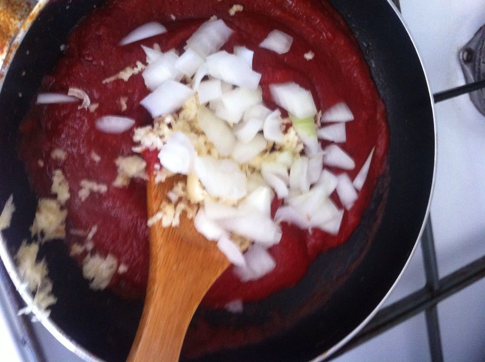 Add tomato sauce, chopped onions, and crushed garlic.