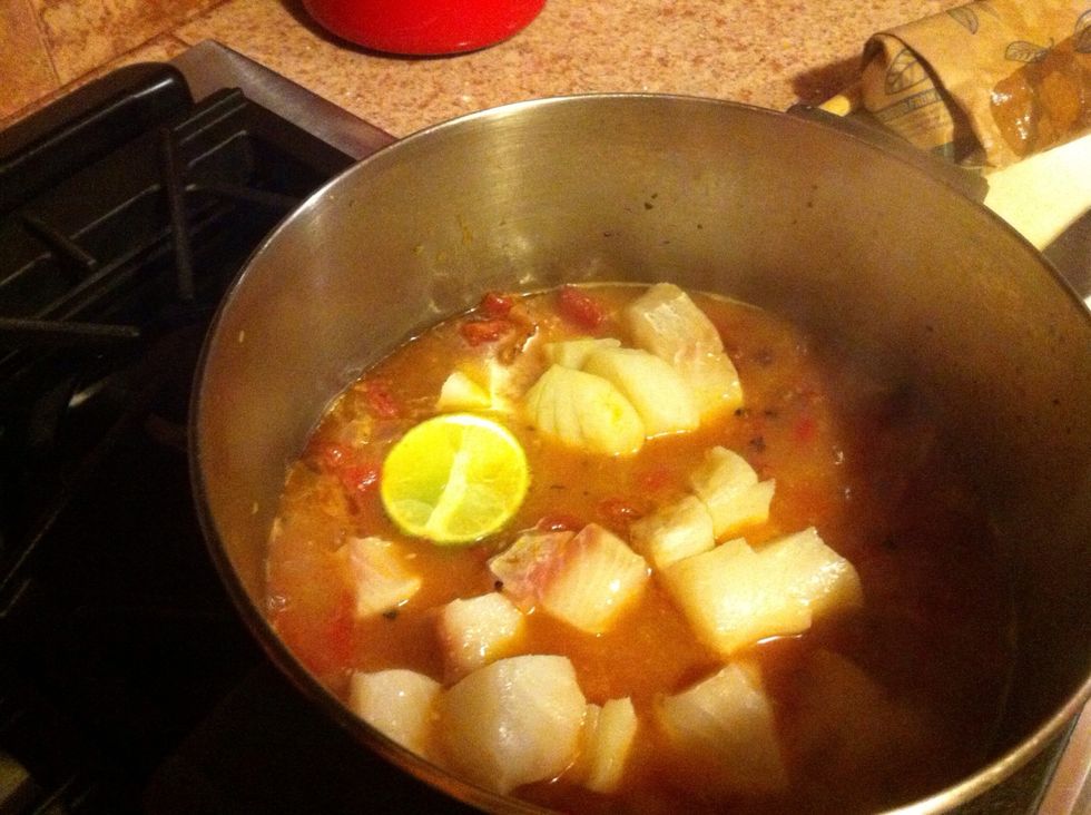Add tomatoes, cod, scallops and lime. Cover and bring back to a boil. Cook for 10 minutes.