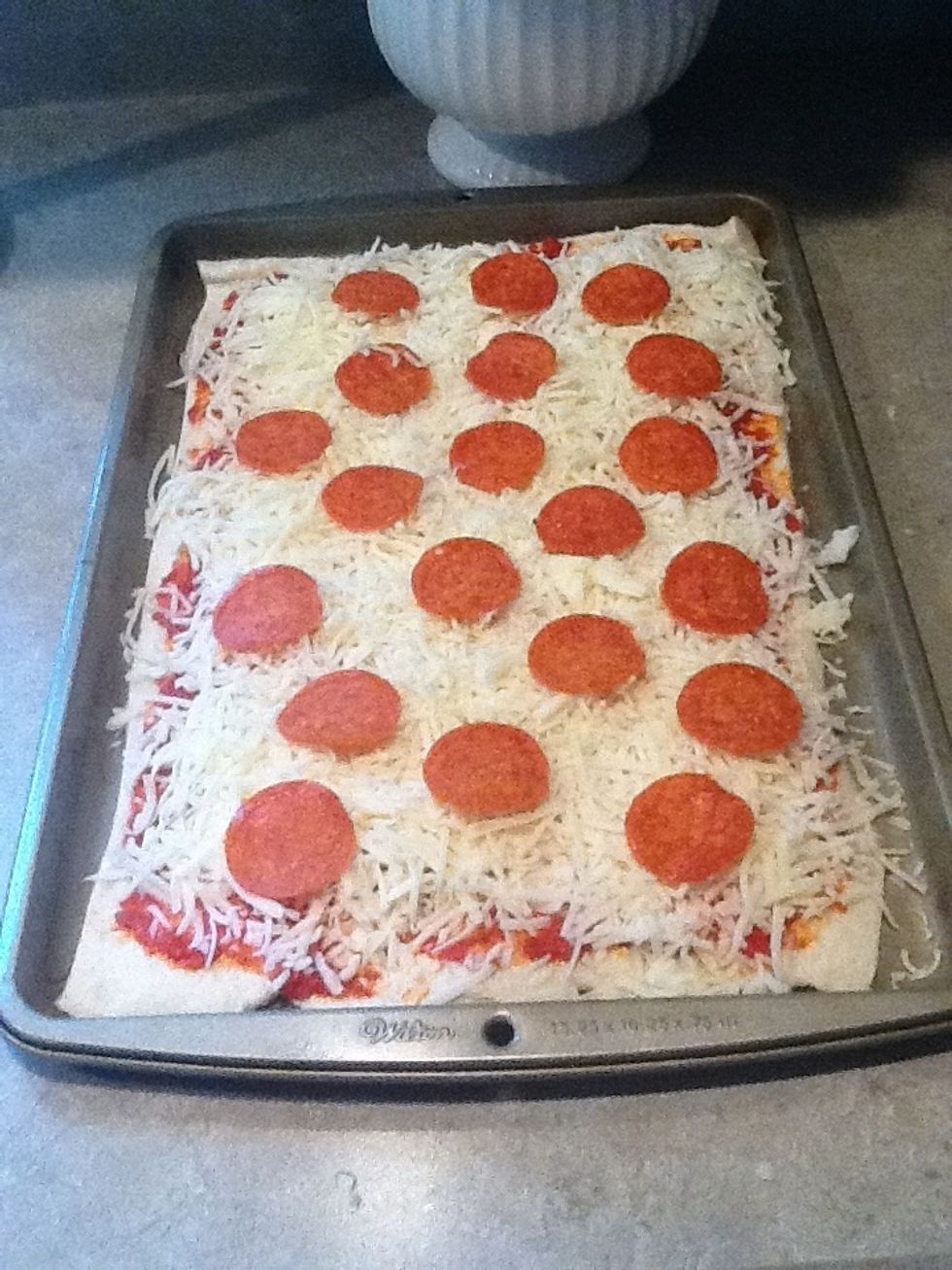 Add toppings to the pizza. Place them on the cheese and do not clump them.