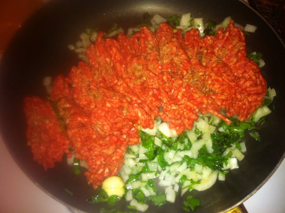 Add two cloves of garlic, medium onion and parsley to olive oil in a medium sauce pan. Add ground beef.