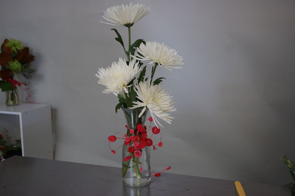 Add two more flowers down by the edge of the vase.