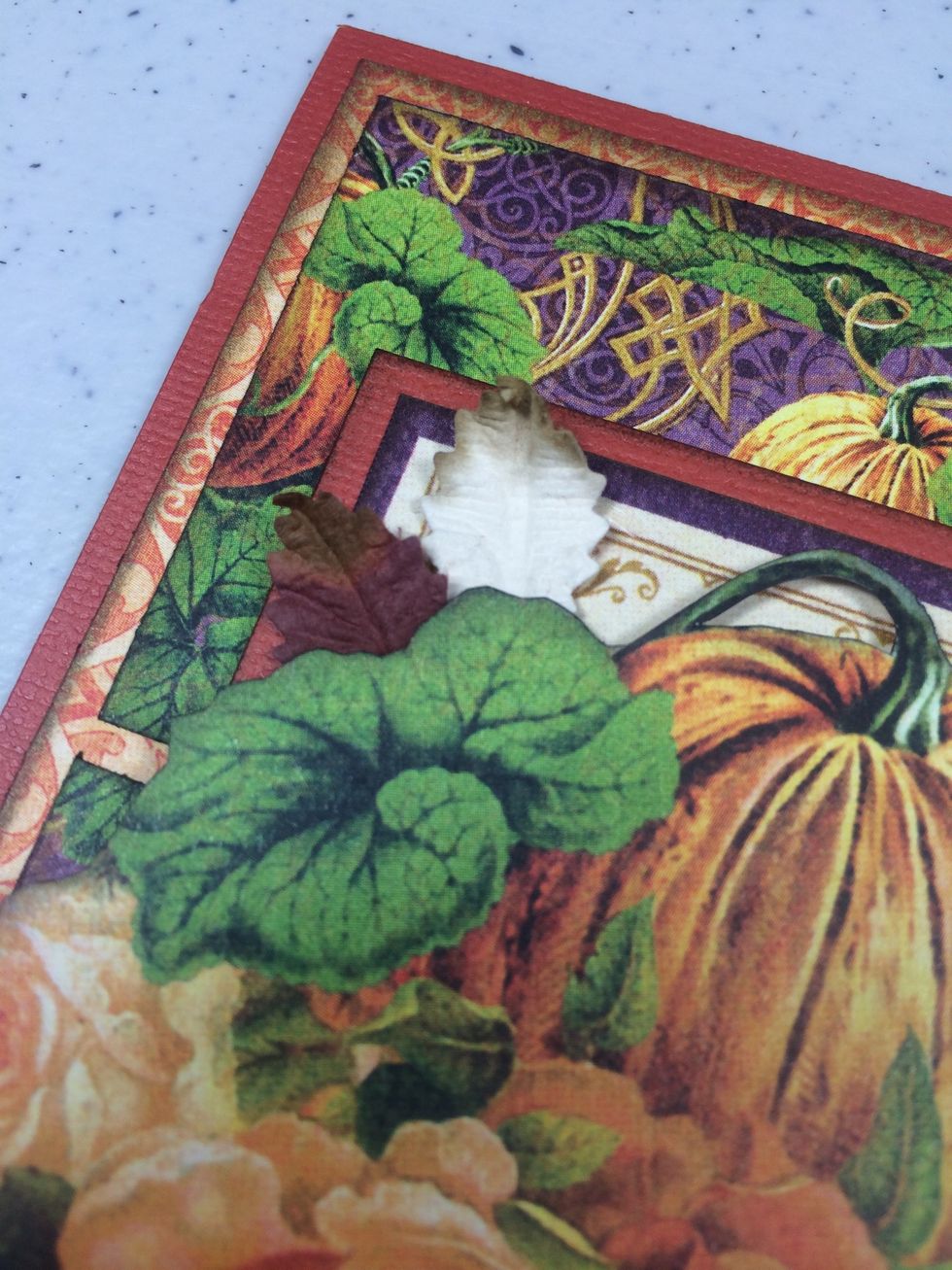 Add two or three more leaves in the upper left area, layering them under the fussy cut image a bit.