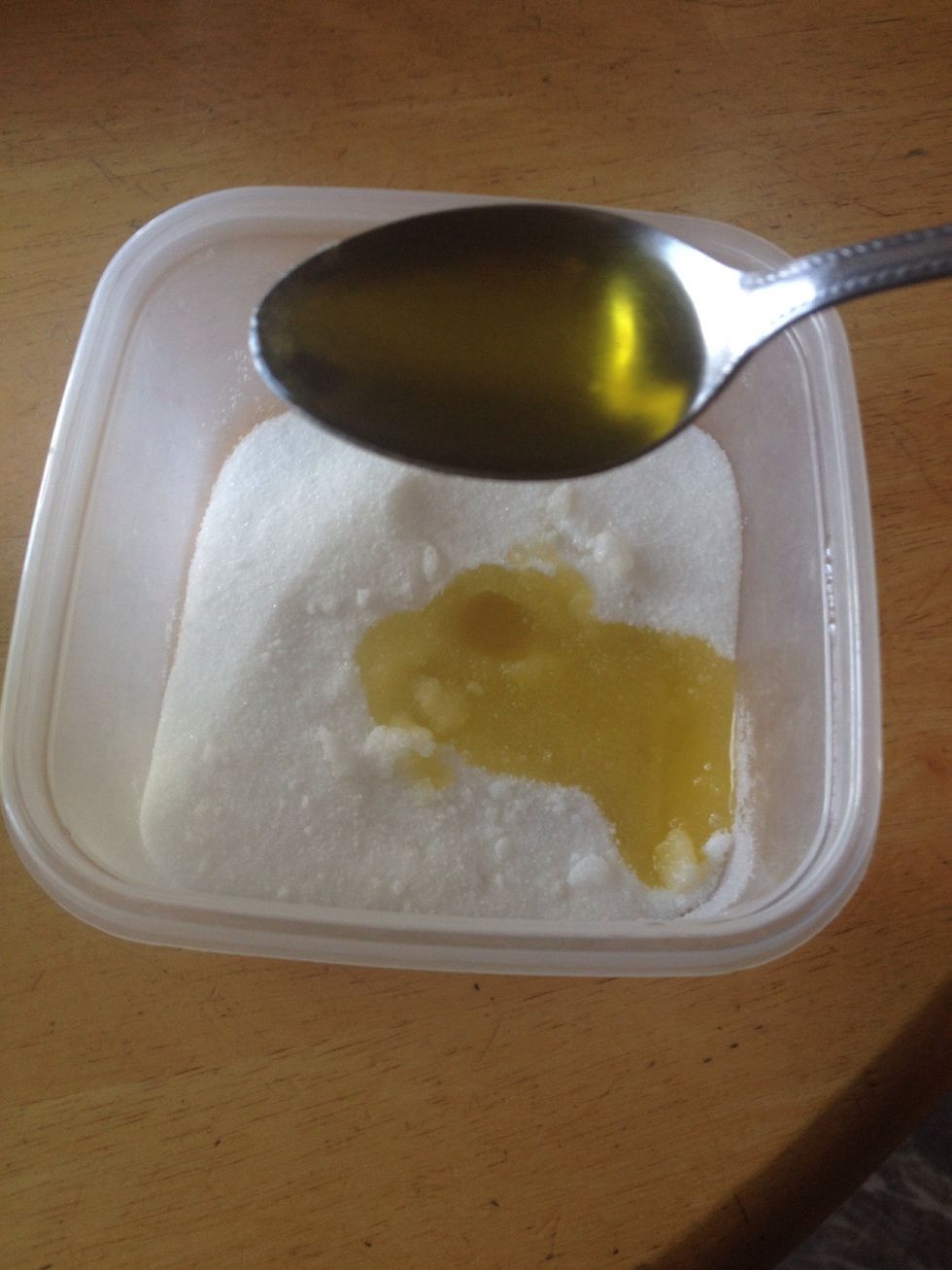 Add two tablespoons of olive oil to the sugar and mix it.