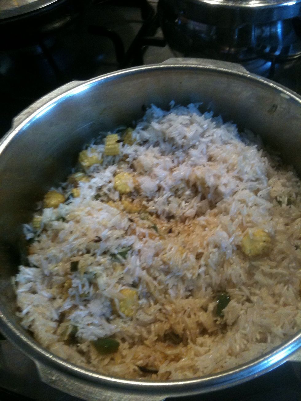 Add unboiled rice, salt, curry powder, garam masala, to the mixture and close the pressure cooker on medium heat, Count up to 2 or 3 whistles.