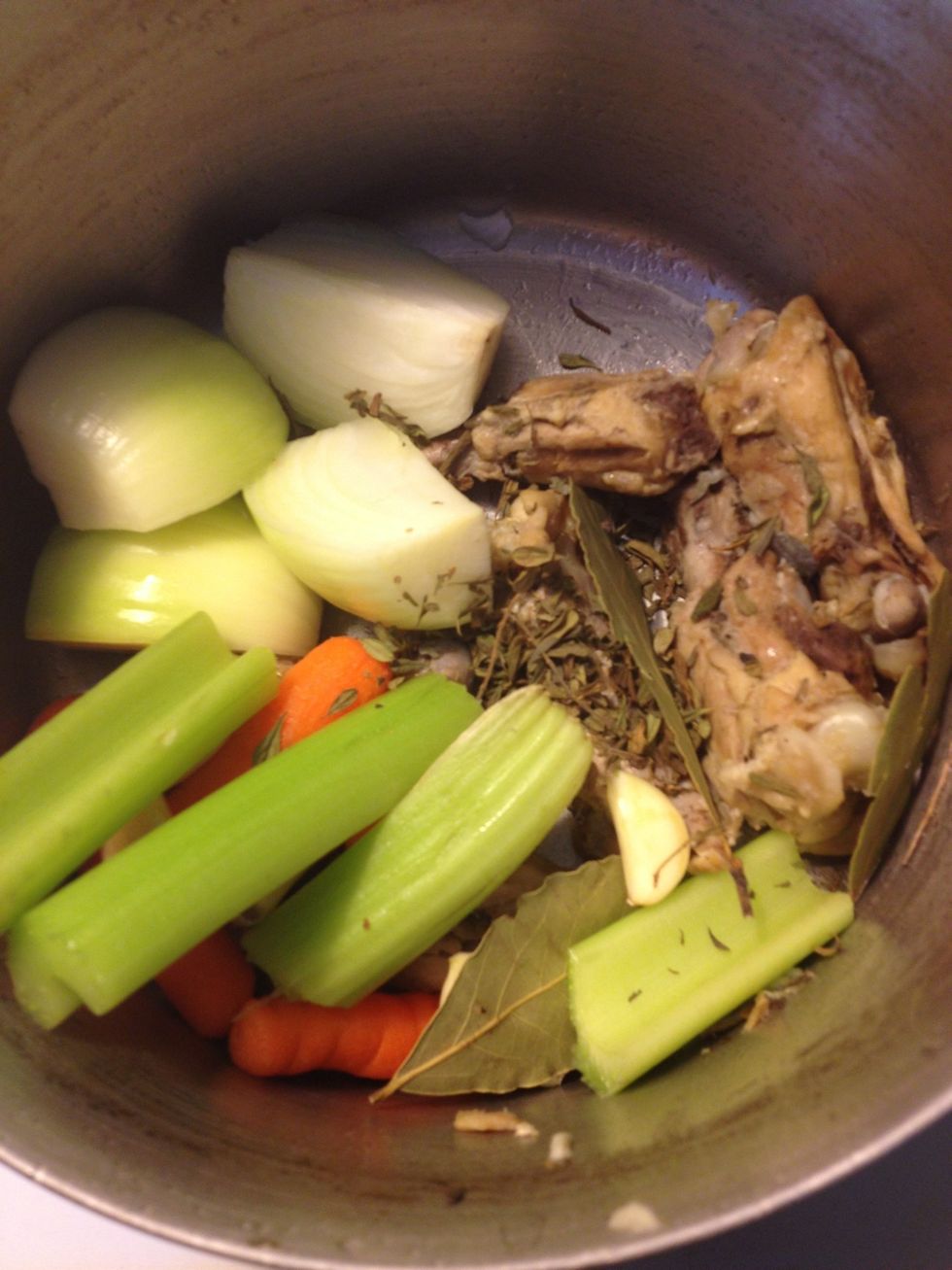 Add vegetables to stock pot along with chicken and herbs. This is my 2nd batch of stock reusing the same pieces of chicken bones and adding fresh vegetables, herbs, and water.
