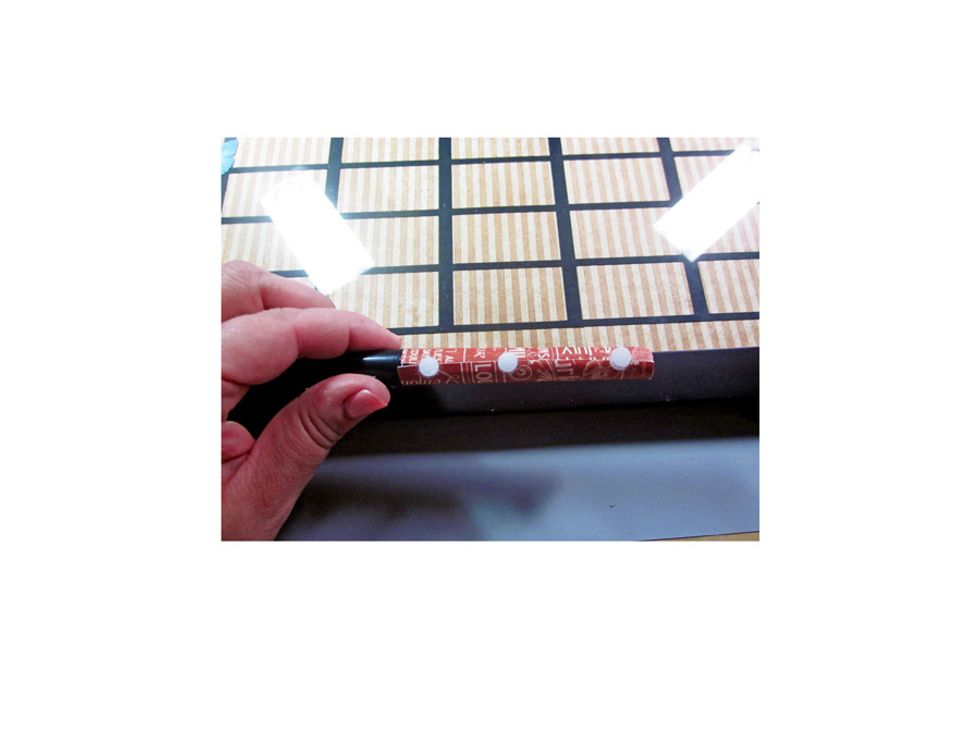 Add Velcro to the one of the dry erase markers that has been wrapped in Graphic 45 paper. Then add the matching dots to the side of the frame. This will hold your pen to mark the days.