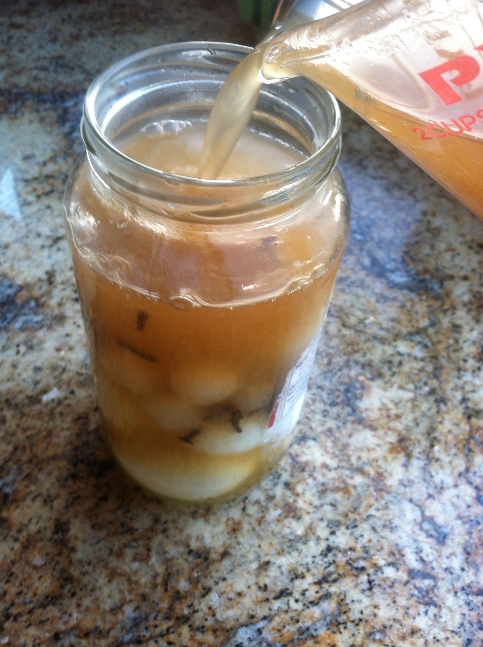 Add vinegar mixture while still hot to the eggs, pearl onions, and cloves.