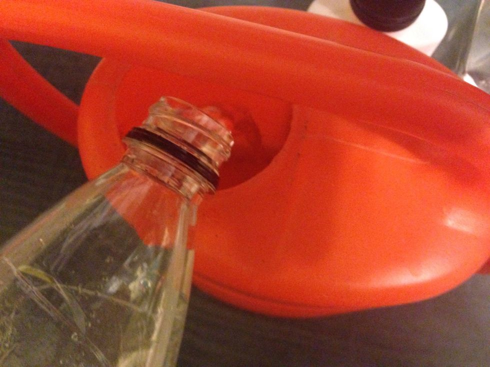 Add water from bottle to the watering can