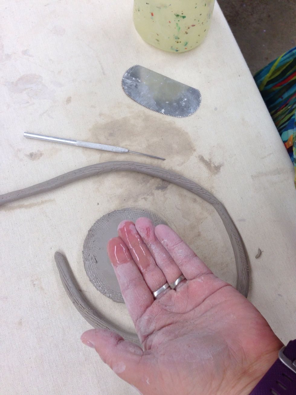 Add water or slip to the scored edges.
