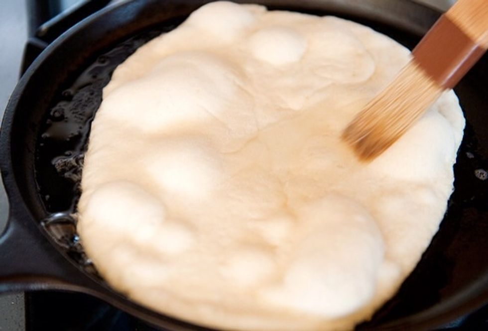 Add water to the top side and flip over, allow to cook until it is nice and brown. U could also instead of flippingthe naan over place the naan under a medium heat grill until brown.