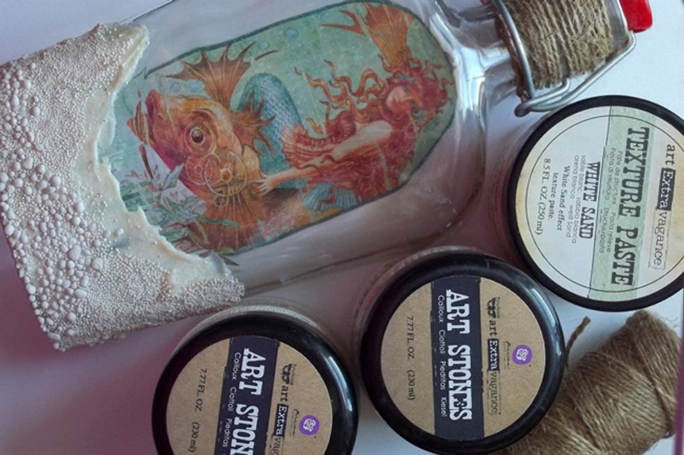 Add White Sand Texture Paste all around the bottom of the bottle. While the paste is still wet, add Art Stones (regular and mini) for extra texture, lightly pressing them into the wet paste.