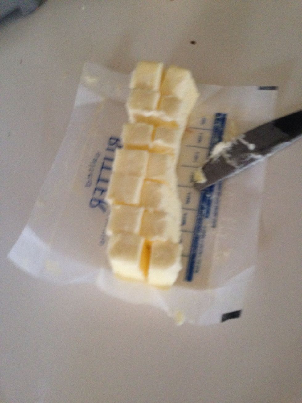 Add your butter. I like to cut it into cubes so it mixes better. You need 2 sticks of butter for this recipe. I have read that butter straight out of the freezer makes the best pie crusts.