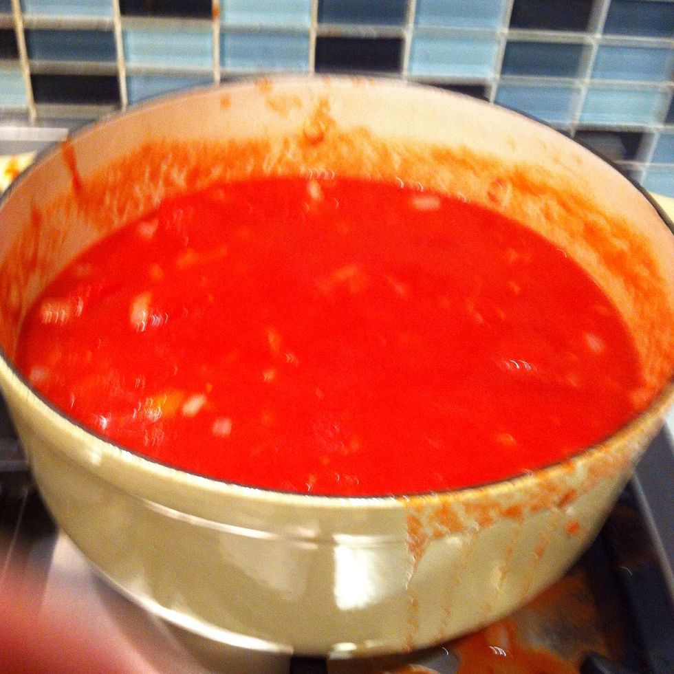Add your canned tomatoes and 200ml of water to the onion mixture then, bring to the boil and simmer over medium low heat, stirring occasionally to break up the tomatoes for 20 minutes.