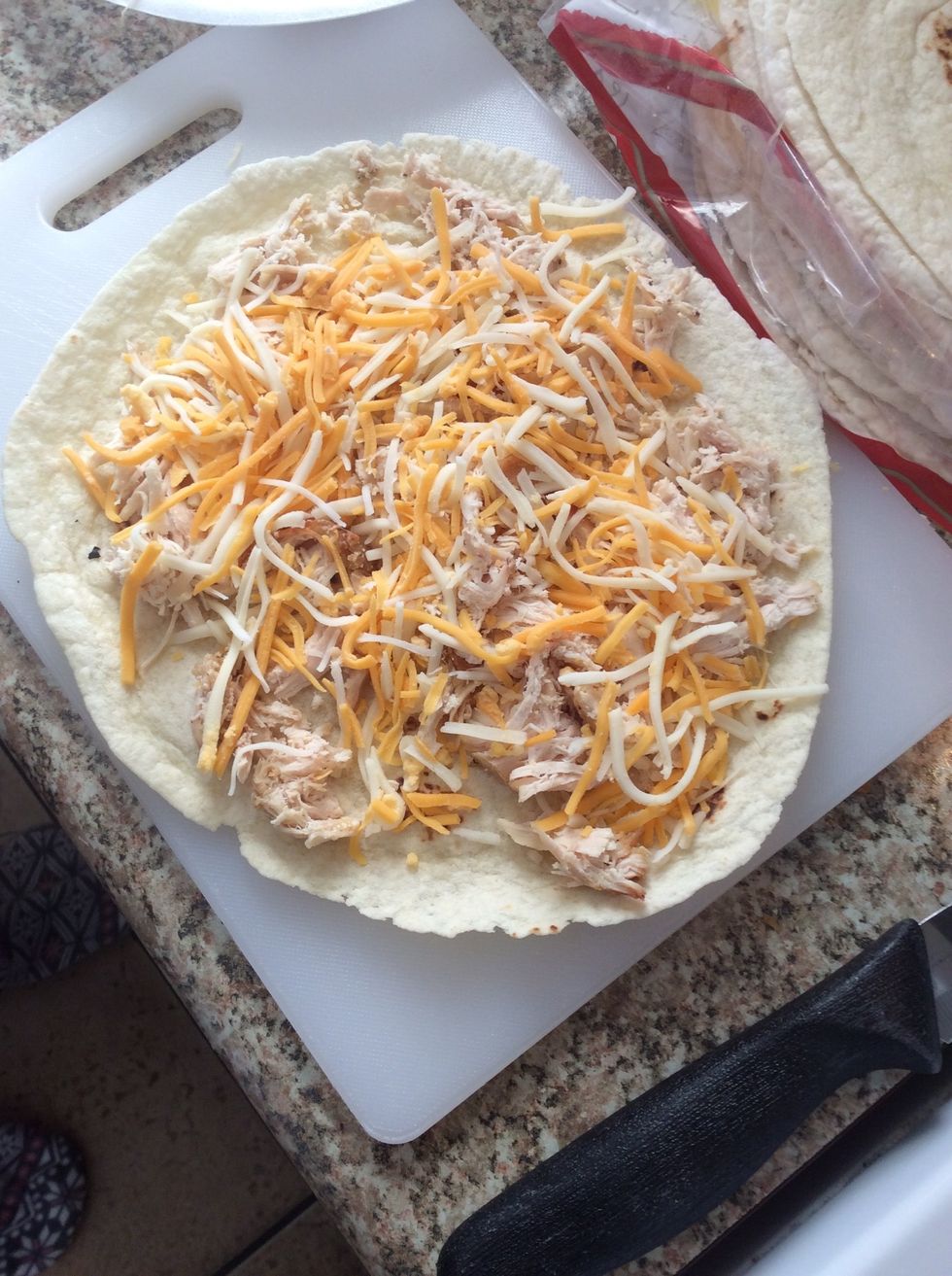 Add your chicken and cheese. Start heating your top piece of the Quesadilla.