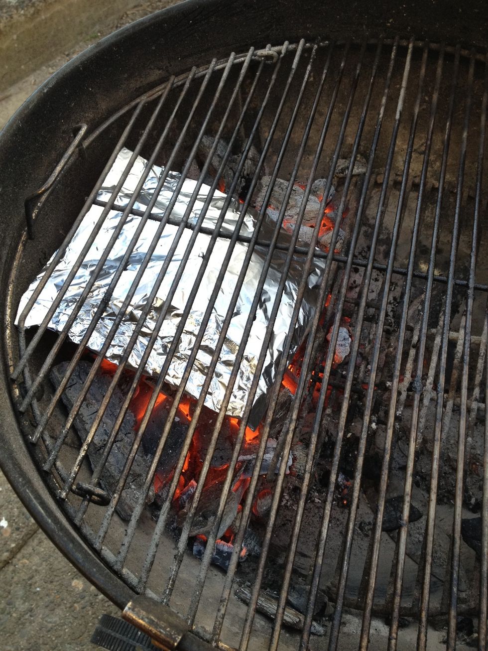 Add your foil packet directly on top of the coals, hole side up.