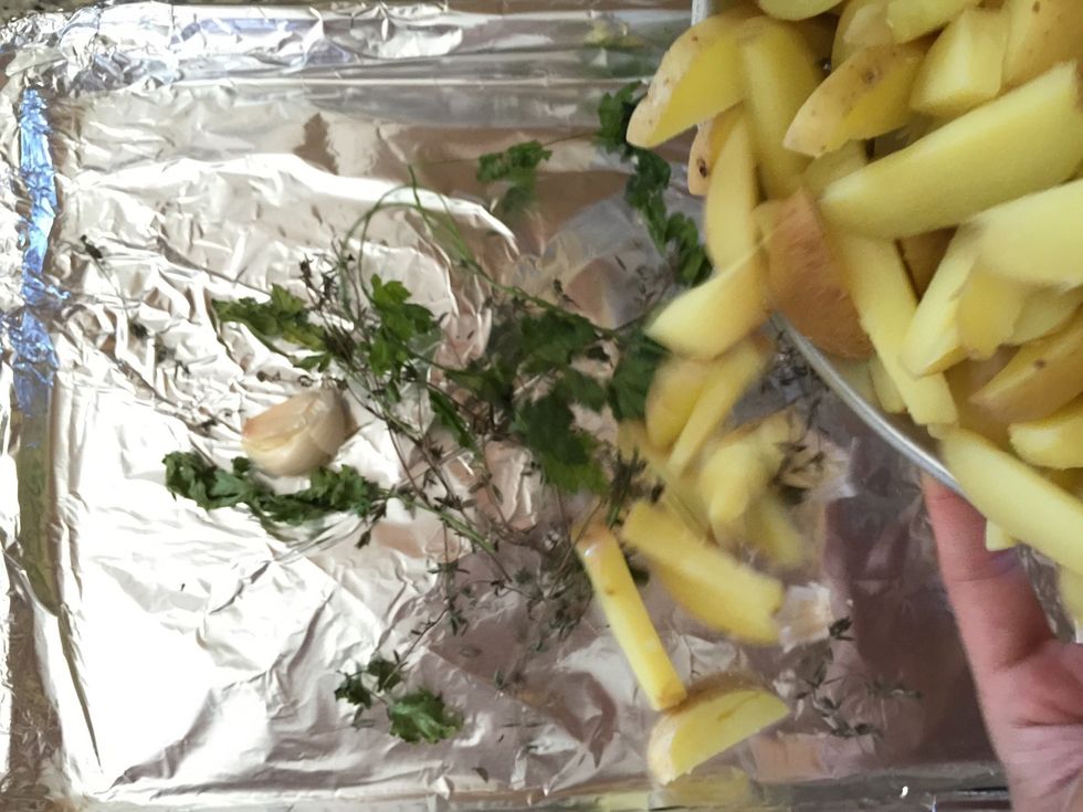 Add your fries to the herb mixture on the sheet pan.