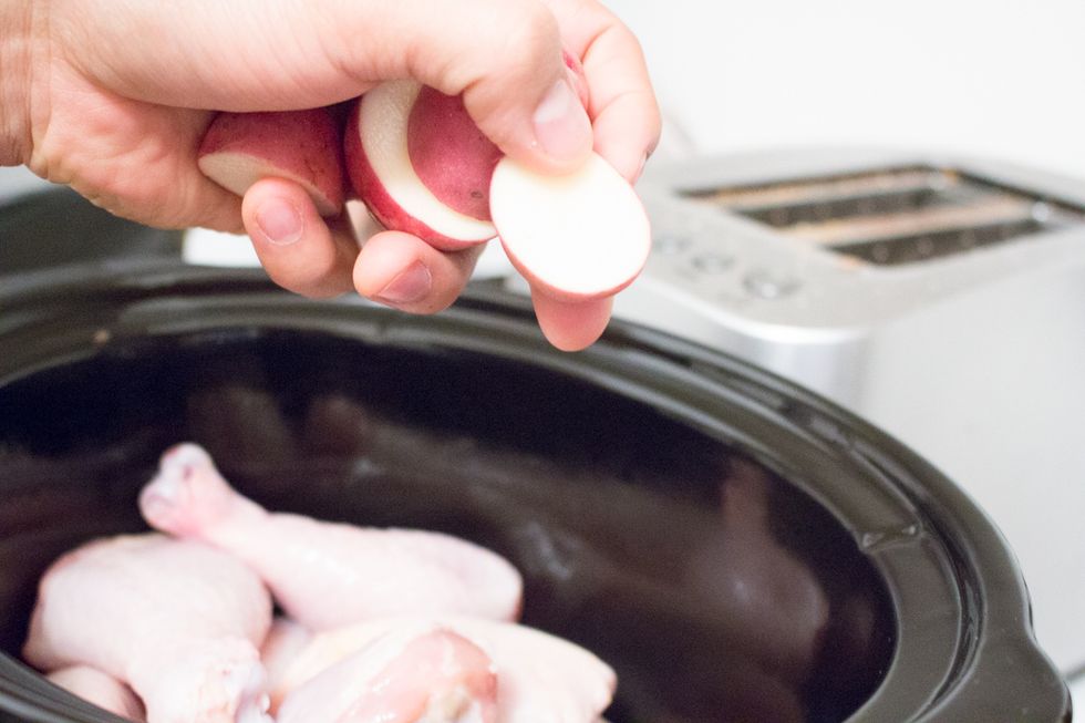 Add your halved mini red potatoes to slow cooker.