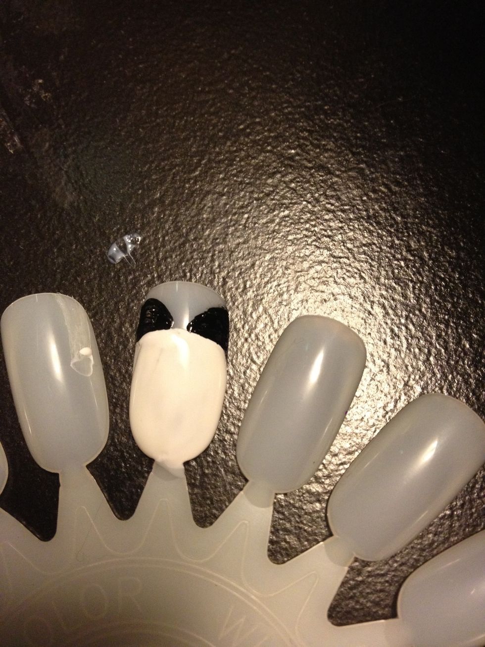 Add your pandas ears by taking a Striper, or small paint brush and creating 2 half circles above your pandas head