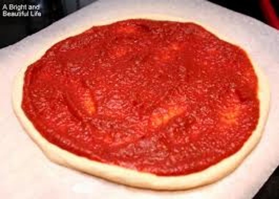 Add your pizza sauce at the top of the pizza dough. PS Be careful with adding the sauce it's messy!